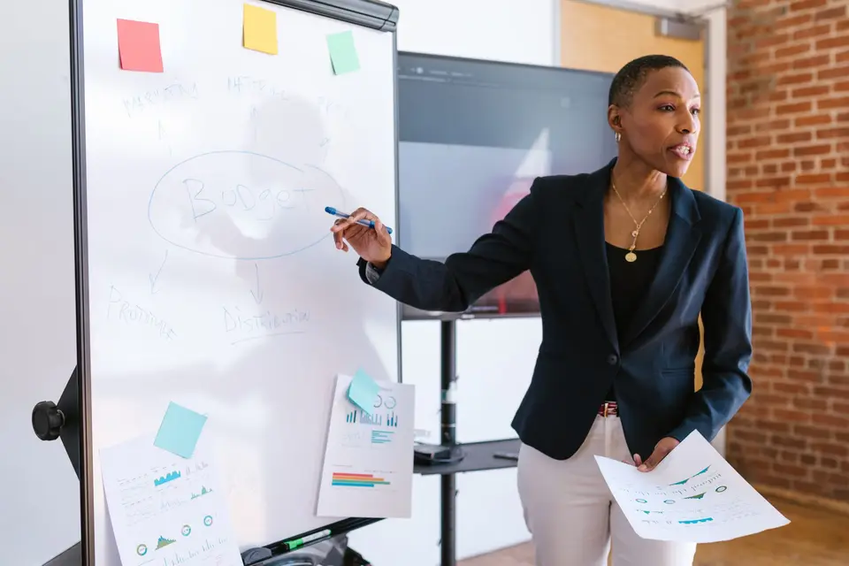 Beraterin erklärt eine Strategie an einem Whiteboard