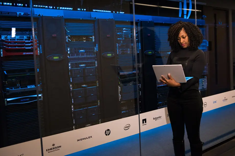 IT-Fachfrau mit Laptop vor Serverschränken