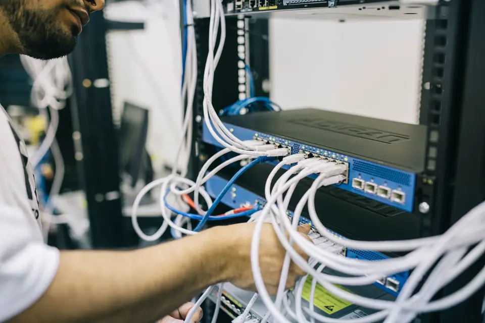 Techniker steckt Netzwerkkabel in einen Server