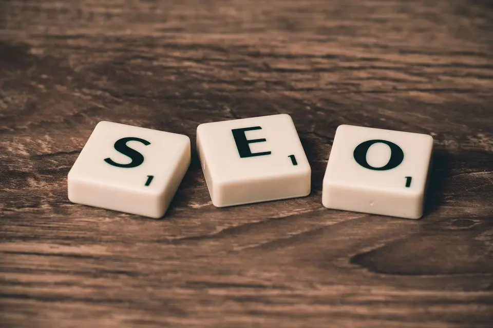 Drei Buchstabensteine bilden das Wort SEO auf Holz